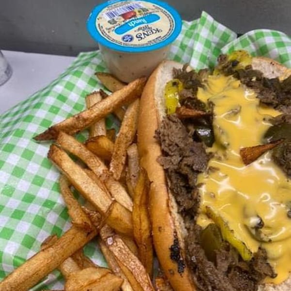 Philly cheesesteak with melted cheese, peppers, and onions, served with fries and ranch dressing.